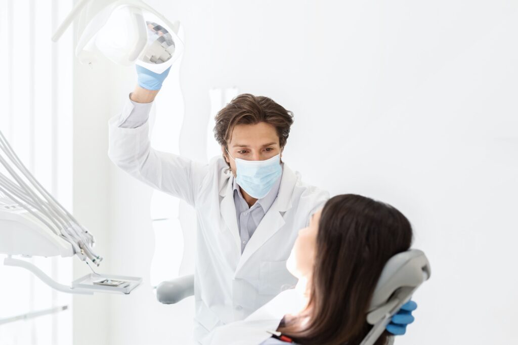 Attentive dentist listening to female patient in cabinet