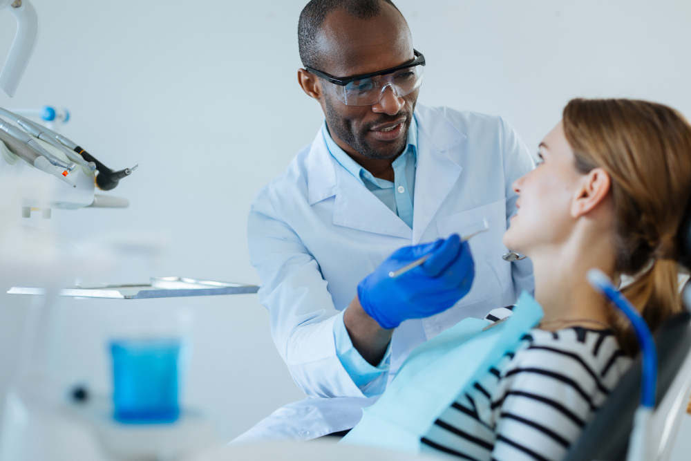 Dentistas realizando limpeza dental profissional nos dentes de um paciente em consultório.