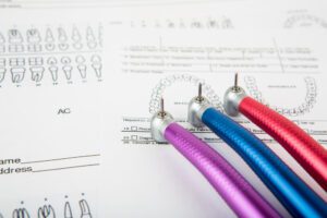 Instrumentos dentários sobre uma carta odontológica, ilustrando o que o plano odontológico cobre em tratamentos e procedimentos.