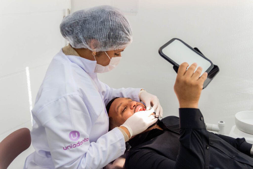 Jovem sendo atendido por dentista credenciado Uniodonto durante consulta odontológica